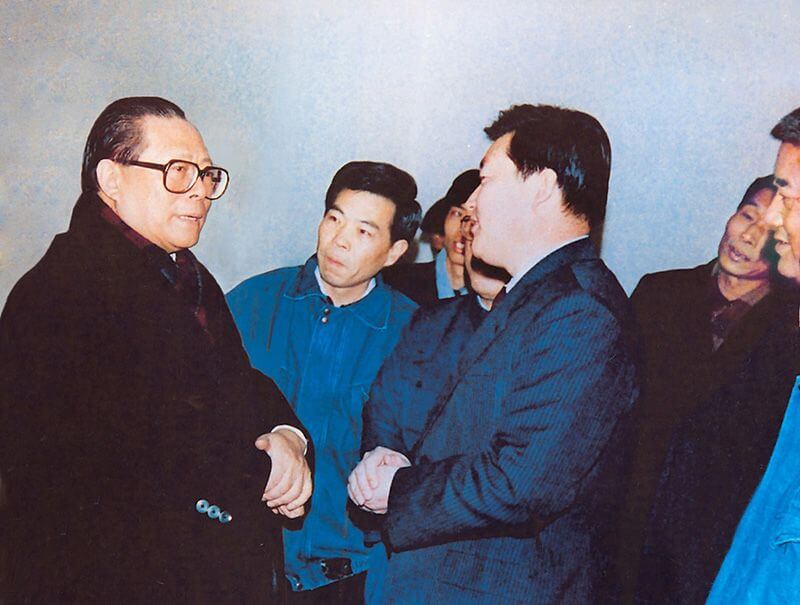 1991年2月5日，时任中共中央总书记的江 泽 民（左一）视察利来国际，他指示：“抓住机遇，深化改革，扩大开放，促进发展，保持稳定。”